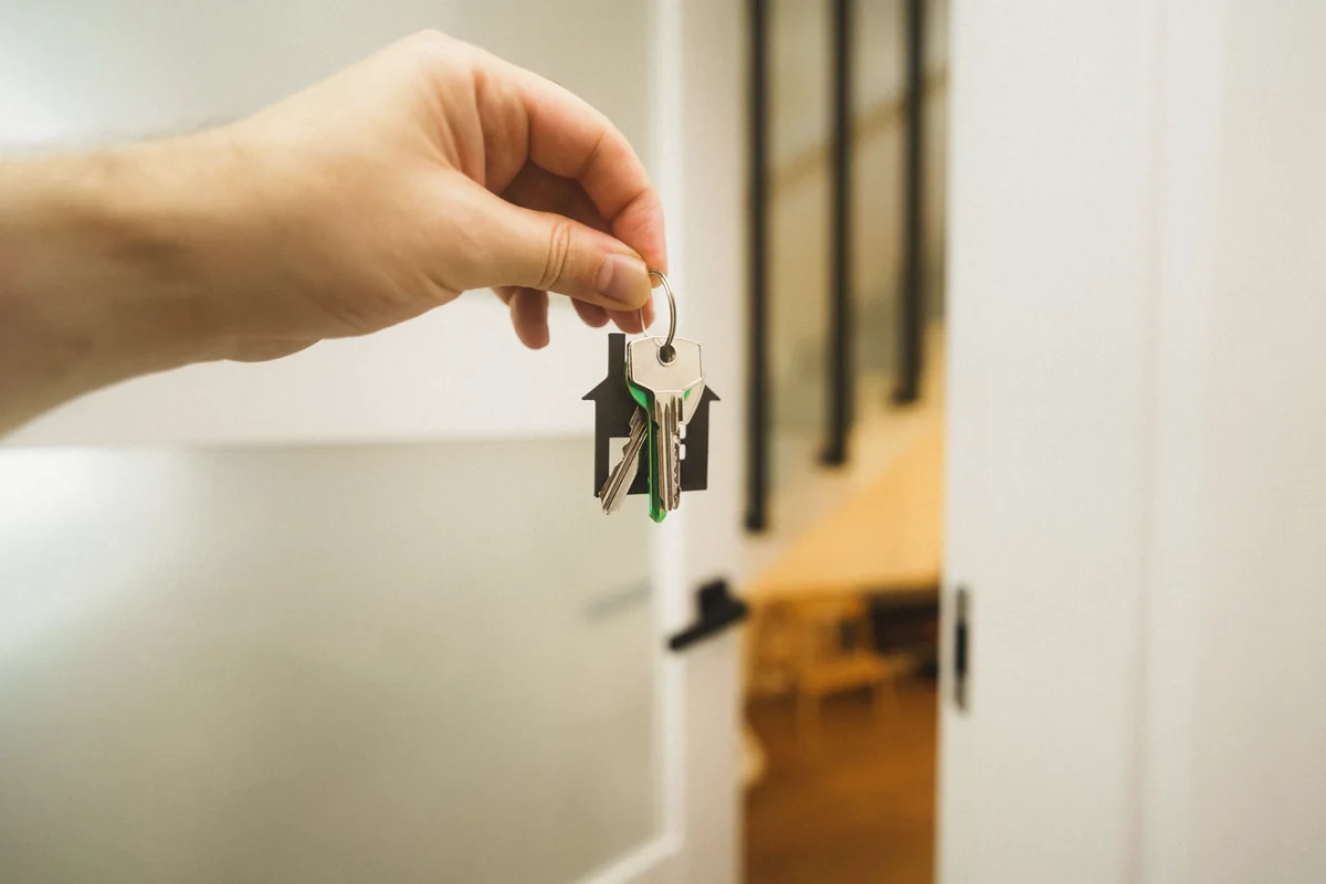 Hand mit Hausschlüsseln in einem hellen Zuhause
